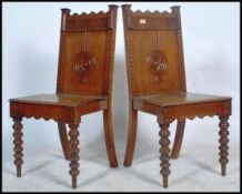 A pair of 19th century Victorian oak hall chairs being raised on carved tapering legs with panel