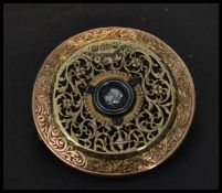 An unusual gilt filigree brooch made from a pocket watch movement having a central white stone.