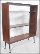 A mid century retro teak wood bookcase cabinet having open shelves and raised on dansette style