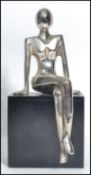 A vintage 20th century Art Deco chrome figurine of a lady raised on a ebonised wooden plinth base.
