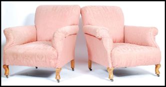 A pair of early 20th century country house Chesterfield / club armchairs being raised on walnut stub