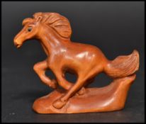 An Oriental Japanese netsuke carved in the form of a horse. Signed to base.
