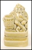 A Royal Doulton stoneware vesta matchstriker modelled as a pipe smoking gnome designed by Harry