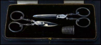 A silver hallmarked cased sewing set consisting of two pairs of silver hallmarked scissors and a