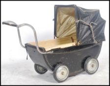 A vintage 20th century childs enamel painted pram in black with the original spoked wheels. The
