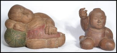 A pair of 20th century Asian carved and painted hardwood Buddhas, both of typical poses. Highest