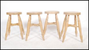 A set of four English country style beech wood stools having a ' x ' frame stretcher and turned