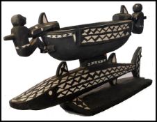 A vintage 20th century carved from an ebonised wood ceremonial Apira shell inlay tribal food bowl,