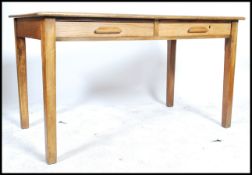 An early 20th century industrial office beech wood AirMinistry style desk raised on four square legs