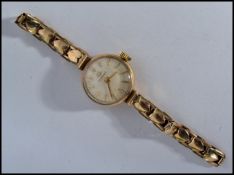A hallmarked 9ct gold Tissot wristwatch cocktail watch. The silvered dial having baton numerals. Set