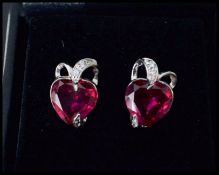 A pair of white gold and ruby and diamond earrings having heart shaped rubies. Complete in