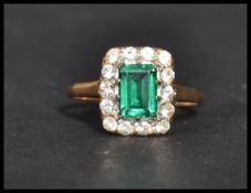 A vintage 20th century hallmarked 9ct gold green and white stone ring. The central emerald cut green