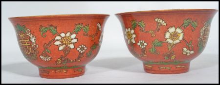 A pair of 19th century Chinese porcelain prayer bowls having red grounds decorated with medallions