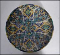 A  believed Persian tin glazed pottery wall charger - large bowl being handpainted with geometric