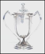 An early 20th century silver hallmarked three handled pepper pot pepperette raised on a circular