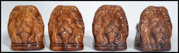 A set of four 19th century ceramic Sash window stays in the form of lion heads having a treacle