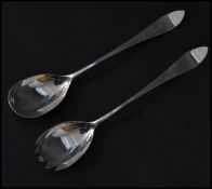 A pair of early 20th century silver hallmarked salad servers / serving spoons being hallmarked for