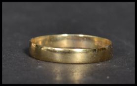A hallmarked 9ct gold band ring of plain form. Size P.