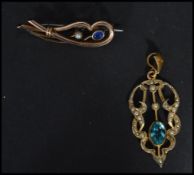 A 9ct gold (unmarked) scrolled brooch having a blue stone with a pearl weighs 2.9 grams along with a