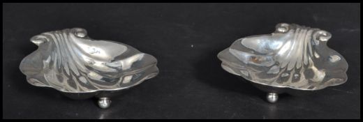 A pair of 20th century Canadian sterling silver butter dishes in the form of clam shells raised on