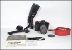 A vintage 20th century Canon T90 35mm camera with a Tokina 35mm - 200mm SX - X352 lens and a