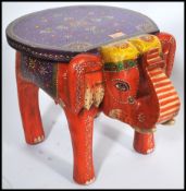 An unusual 20th century handpainted elephant stool in vivid colours having a circular seat above.