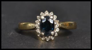 A vintage 20th century hallmarked 9ct gold diamond and sapphire ring. The central blue stone adorned