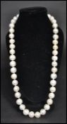 A vintage freshwater pearl necklace strand. The pearls of varying form but similar size. Claw clasp.