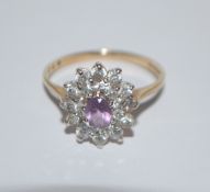 A hallmarked 9ct gold cluster ring set with a central purple stone surrounded by a twin halo of CZ.