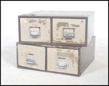 A pair of vintage industrial twin drawer filing drawers having pull handles and index card