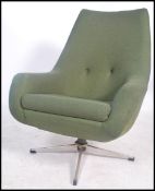 A vintage mid century retro swivel armchair raised on a polished steel five pointed base having an