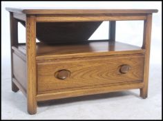 A 20th century Ercol ' Golden Dawn ' elm wood side table unit having a drop leaf table top with