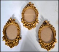 A group of three 20th century gilt plaster moulded picture frames. The glazed frames moulded in