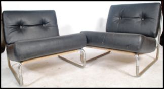A pair of retro 1970's retro black vinyl and tubular chrome open armchairs. Each of simple form with