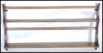 A 20th century Ercol golden dawn hanging plate rack. Beech and elm wood with twin shelves and shaped