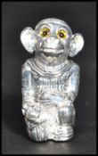 A silver plated pin cushion in the form of a monkey wearing a hat in royal dress.