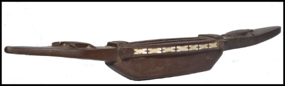 A 20th century unusual tribal carved bowl / musical instrument / game, having a single carved