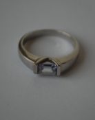 A hallmarked 9ct white gold ring  being set with a pale purple emerald cut stone.  Hallmarked