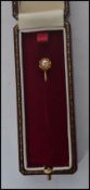 An early 20th century edwardian stick pin having a 9ct gold pin with a diamond set to a 14ct gold
