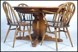 Ercol - Chester - A retro 1980's elm round extending table raised on the cross wide splayed legs