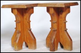 A pair of solid heavy oak ecclesiastical refectory stools of planked cross over construction with