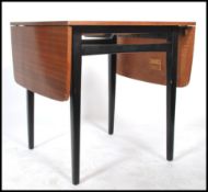 A vintage retro 20th century teak drop leaf extending dining table raised on tapering ebonised