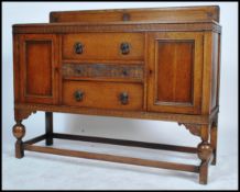 A 1930's  oak sideboard having a central bank of 2 drawers being flanked by cupbords. All raised