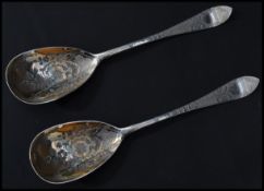 A pair of early 20th century Edwardian silver hallmarked gilt serving spoons having engraved bowls