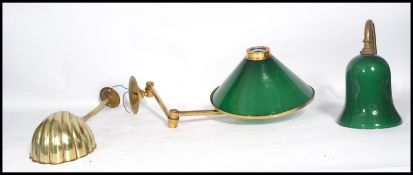 A group of three brass wall light fixtures to include two with green glass shades and another with a