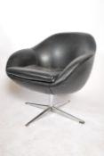 A 1960's black leather type egg swivel desk chair having a metal four point star base in the