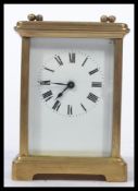 An early 20th century French gilt brass cased carriage clock having bevelled glass panels. The white