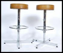 A pair of retro 1970's chrome and faux mustard / tan leather adjustable bar - kitchen stools with