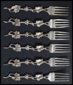 A set of six unmarked silver ( tests as silver ) desert forks, the forks decorated in relief with