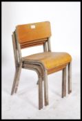 A stack of four mid 20th century childs vintage industrial tubular grey metal framed stacking chairs